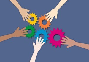 Group hands touching the colourful gears as metaphor for effective teamwork and unity, Group of diverse, Hands together joining concept, Connection, paper cut style.